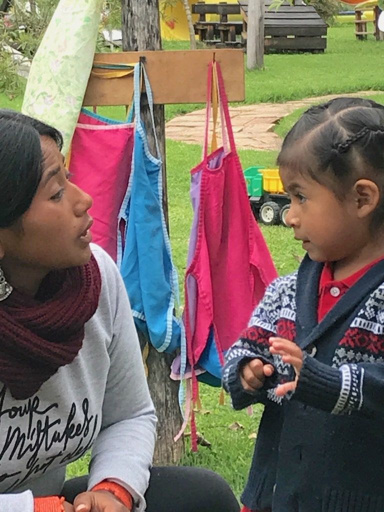 Cuiadora con niña y mandiles - Fundacion Ami